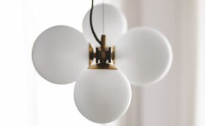 PLANETA Lampe design en acier bruni et laiton brossé avec abat-jours en verre soufflé blanc satiné. Disponible chez D-Style Interior.