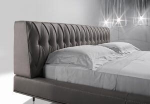 lit McQueen Night, un lit en cuir haut de gamme avec tête capitonnée artisanale et pieds métalliques élégants. Disponible chez D-Style Interior.